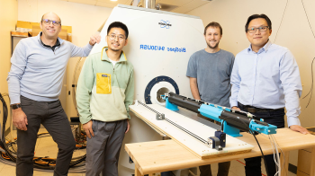 Ian Shih, Scott Tyler Albert, Sheng Song and Adam Hantman pose in front of an MRI machine in the Shih Lab.